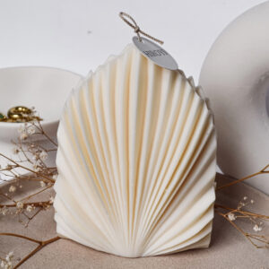 Handgefertigte Calisco-Kerze in eleganter Fächerform aus veganem Sojawachs, Farben Beige und Creme, dekorativ auf Tisch inszeniert – mediterranes, beruhigendes Design.